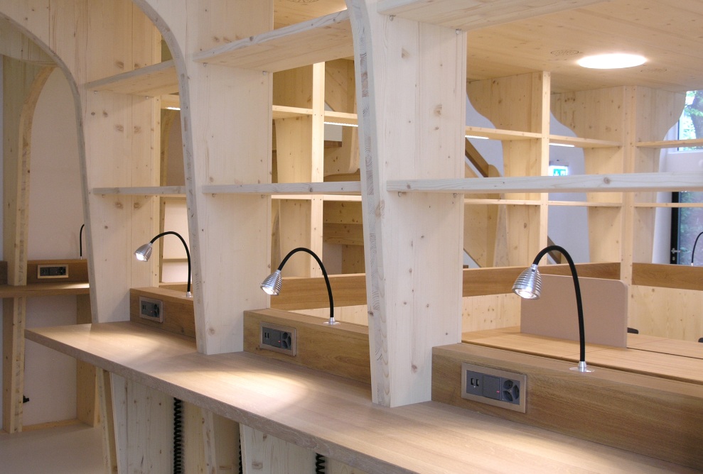 La prise de vue montre une salle lumineuse avec beaucoup d’espace pour apprendre et étudier, entièrement aménagée en bois, dans la Stadtschule de Saint-Gall.