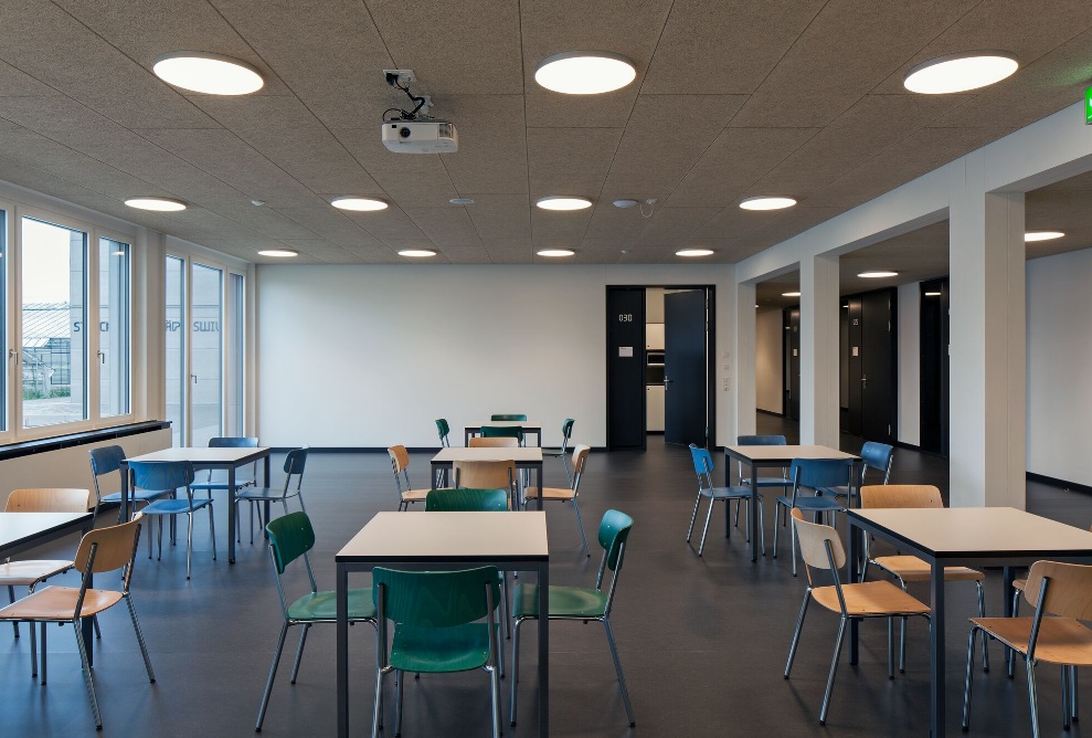 Intérieur du centre de compétences Strickhof avec des tables et des chaises 