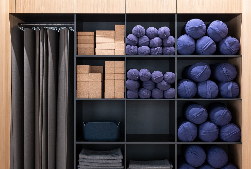 Yoga space in Sutra House with timber interior finishing and open storage for yoga equipment.