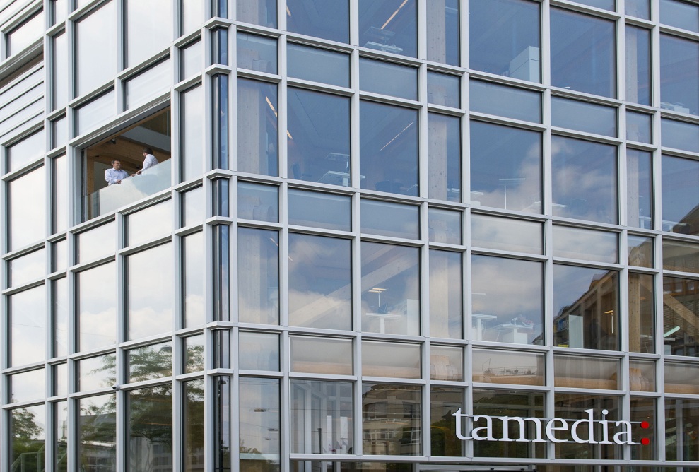 Façade vitrée du nouveau bâtiment de bureaux Tamedia avec vue sur la structure porteuse en bois