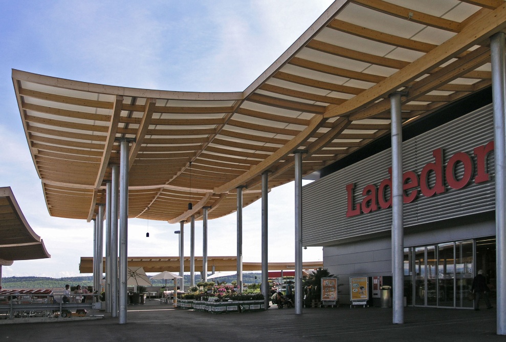 Prise de vue de la zone d’entrée du centre commercial Ladedorf avec couverture en bois