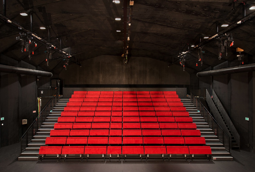 Blick auf die rote Bestuhlung des Theaters mit schwarzem Hintergrund