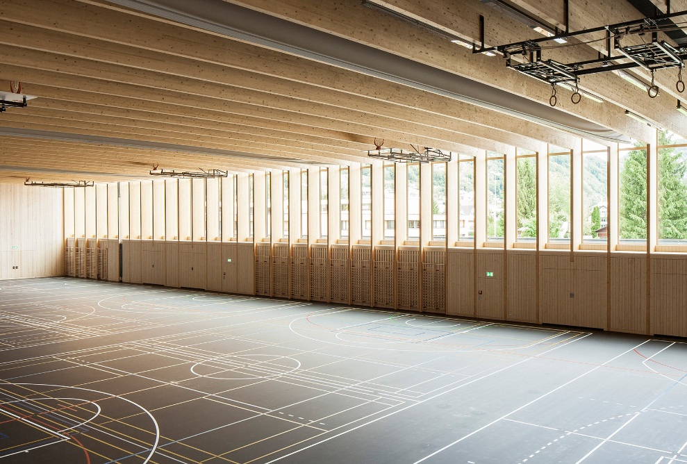 The photograph shows the wooden wall and ceiling structure in the Sargans sports hall