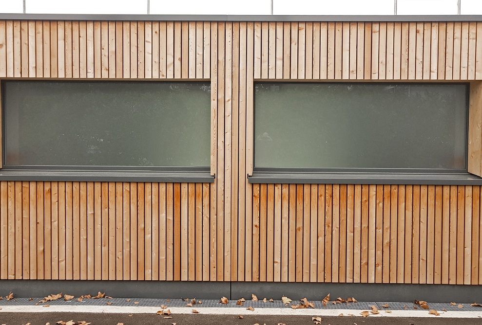 Vue détaillée de la façade en bois avec deux fenêtres 
