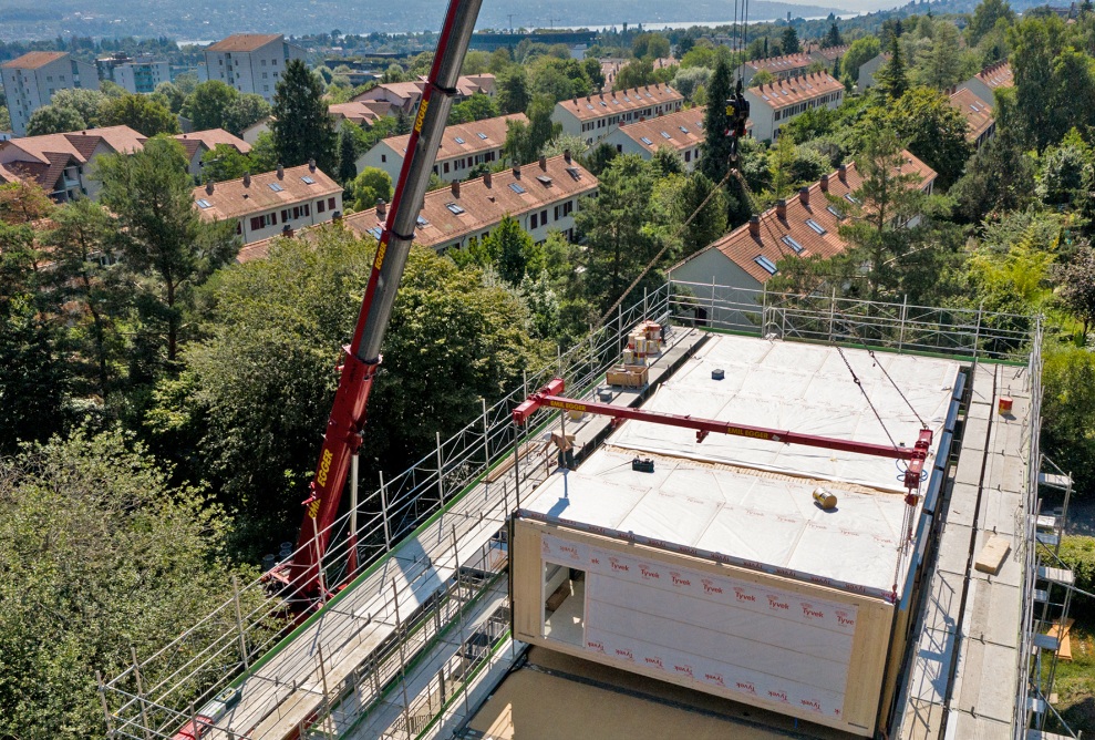 Vue aérienne sur le toit de l’école de Friesenberg avec cinq modules en bois déjà placés sur le toit.