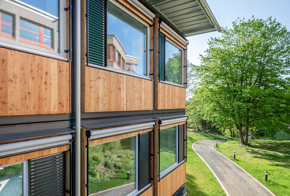 Landscape image with side view of the timber facade of the modular ZM10 Sihlweid school pavilion in Zurich