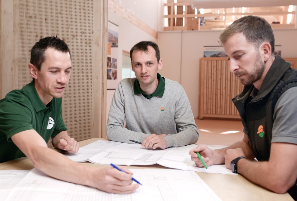 Trois chefs de projet assis dans un bureau pendant une réunion